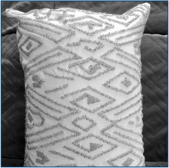 White cushion cover with silver beaded pattern